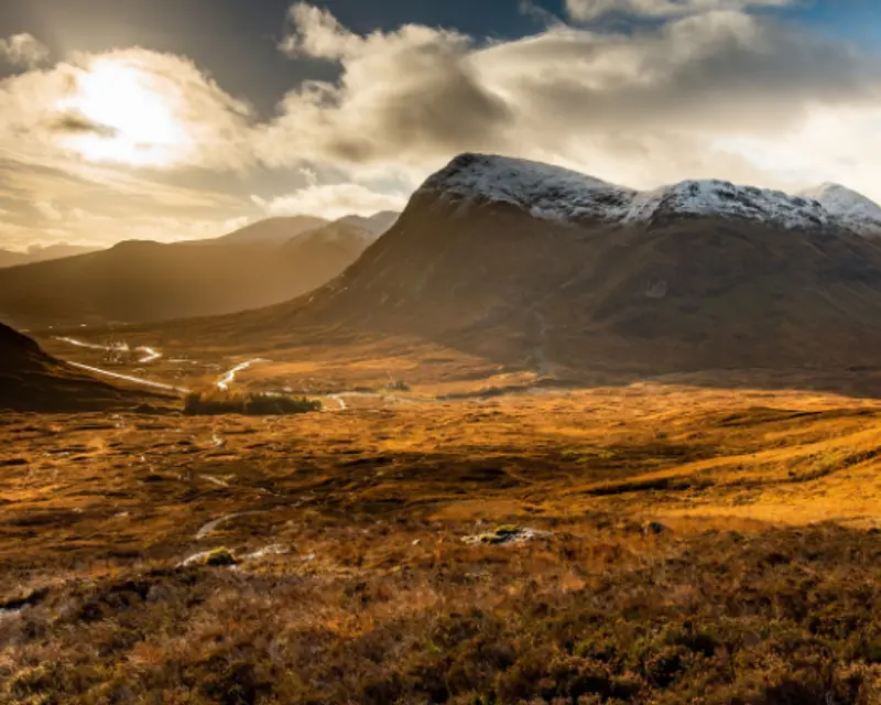 the sun setting over a valley and mountains