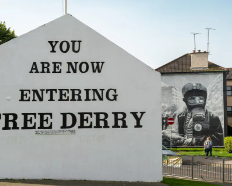 side of a building with the words 'you are now entering free Derry' written on