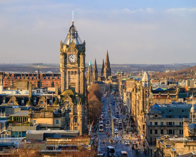 Aerial view of Edinburgh, showcasing the iconic clock tower and historic architecture along a bustling street.