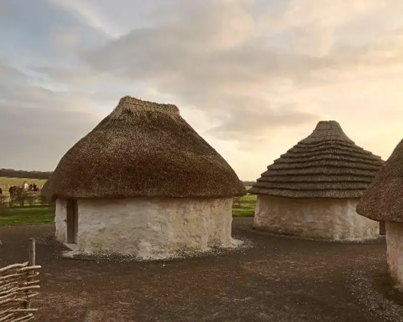 Traditional thatched-roof cottages set against a scenic landscape, showcasing the charm of historic UK architecture.