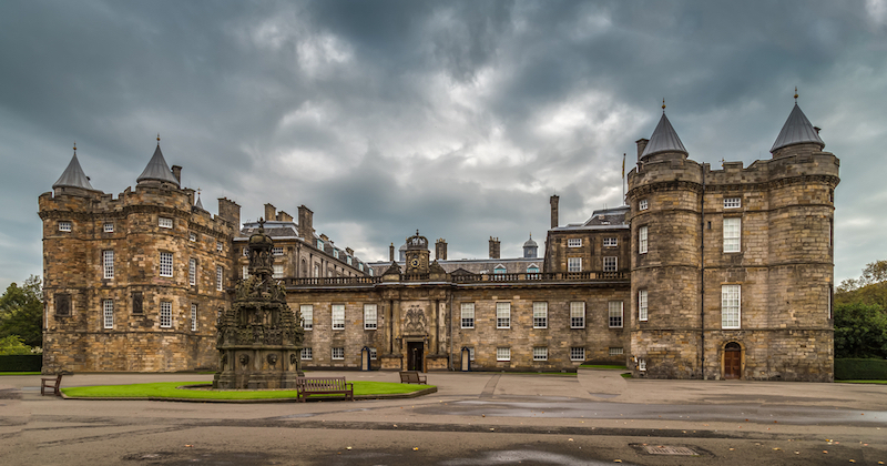 The imposing, grey stone, holyrood palace. One of the sites you can see following flights to Edinburgh from the USA
