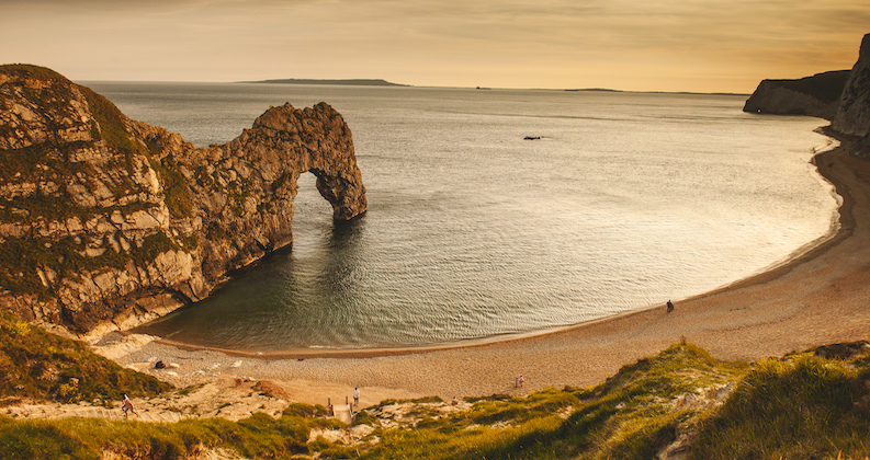 Durdle Door arch stone formation from the cliff edge into the sea