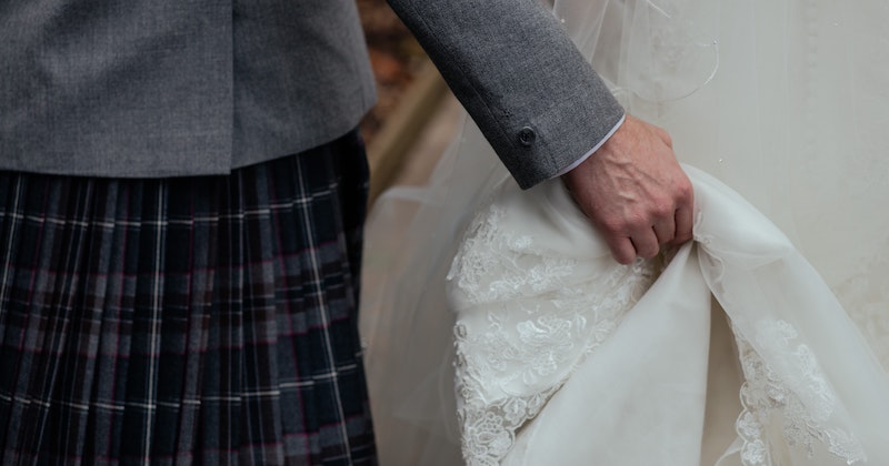 a groom wearing his family tartan and a bride in her wedding dress