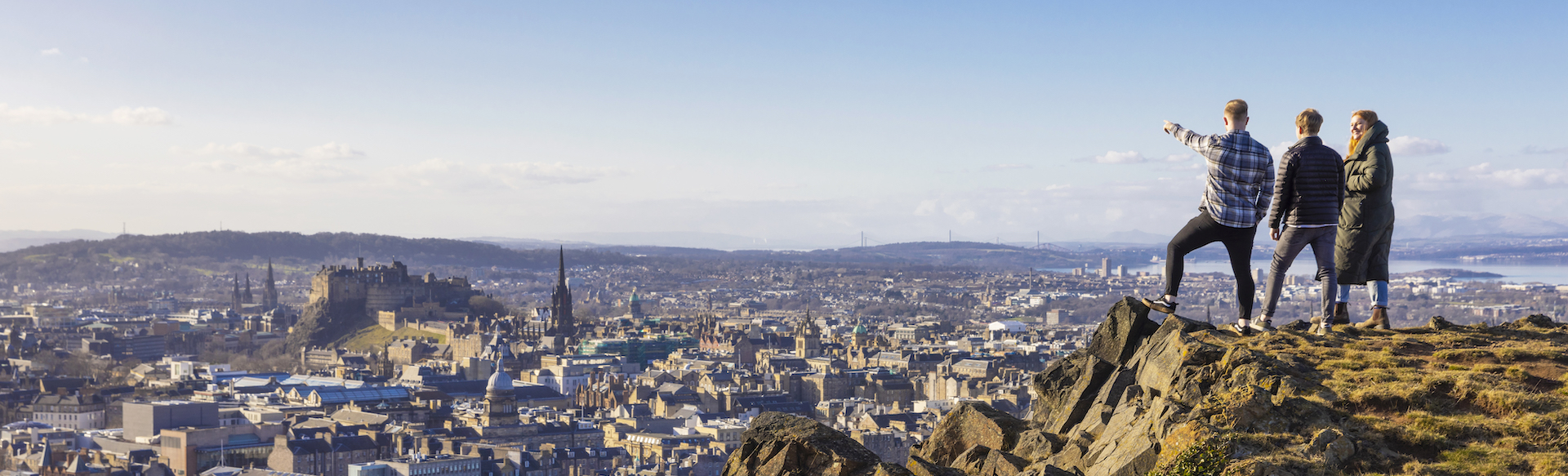 people at the top of Arthur's seat pointing at all the things they can see in Scotland