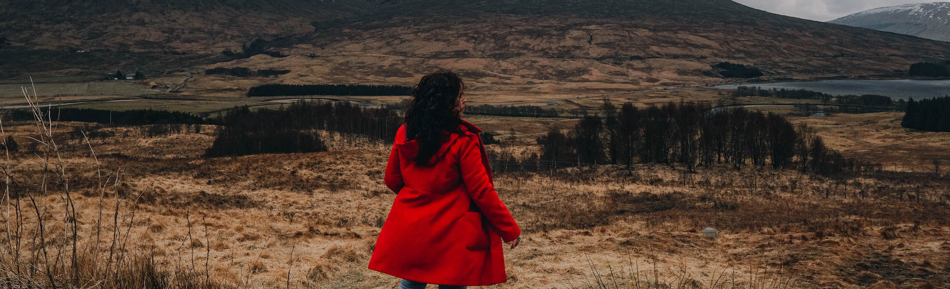 solo traveller wearing a red coat in the UK