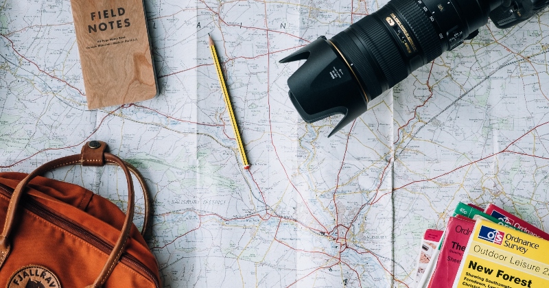open map with a camera and backpack, ready to plan a solo travel trip