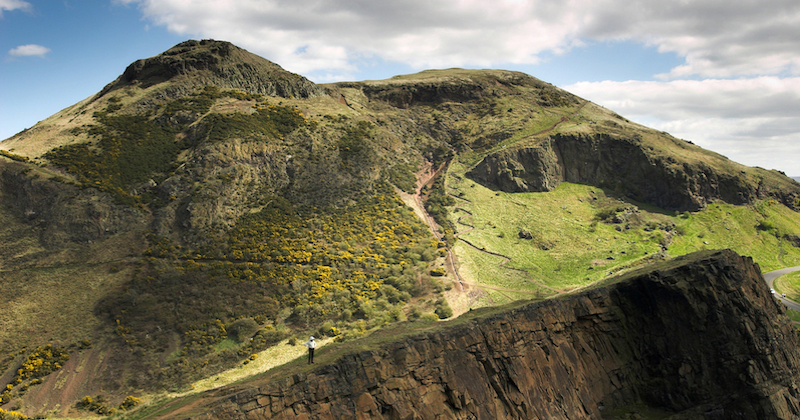 The green peak of Arthur's Seat in Edinburgh under a blue sky