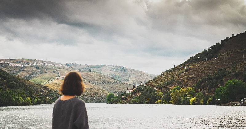 female traveller in Portugal, standing by the lake enjoying the view